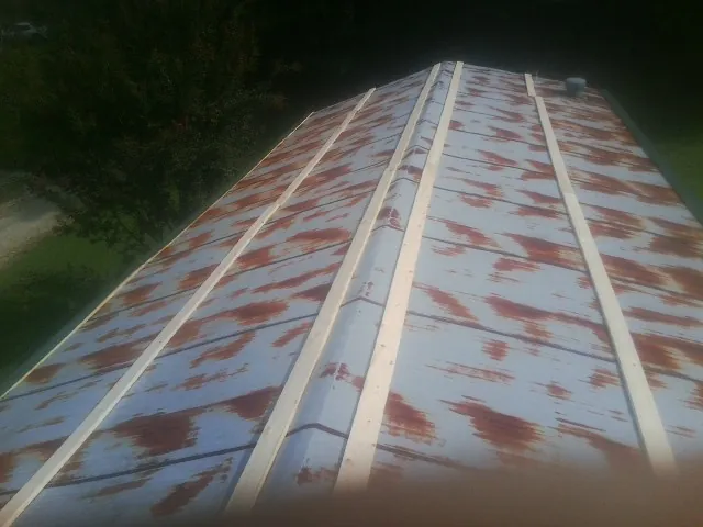 Rusted metal roof panels with new wood purlins before replacement — Storm Damage Roof Repair in Waltham by Roofing Brothers